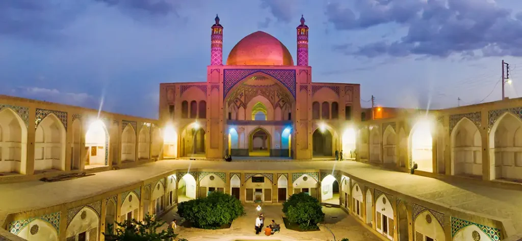 The courtyard of a mosque lit up at night.