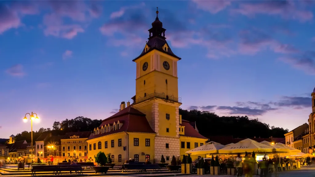 A town square with a clock tower at dusk.