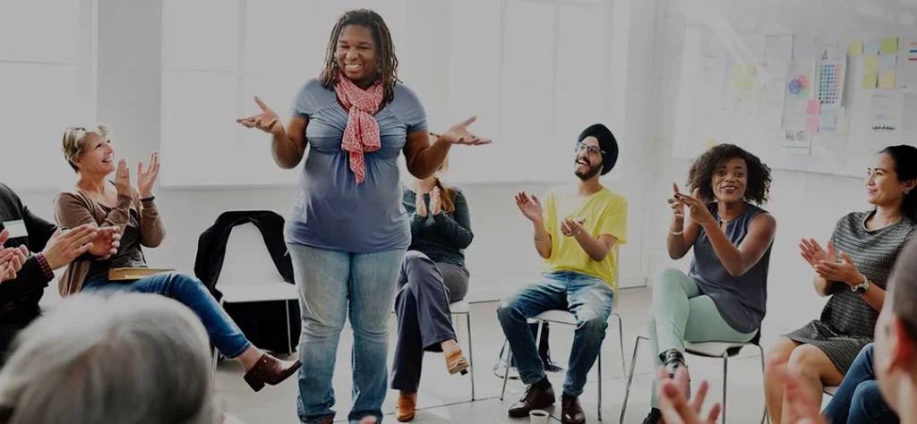 A group of people clapping in a room.